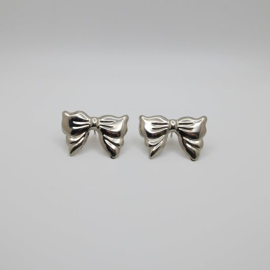Pair of silver bow-shaped earrings on a white background