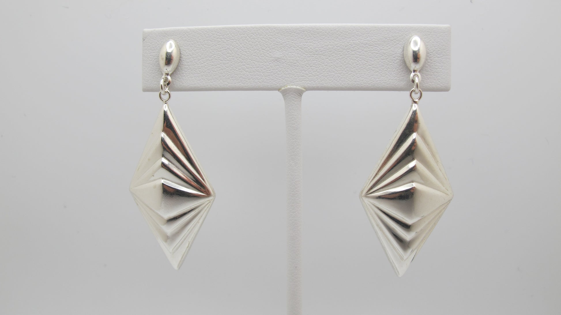 Pair of silver geometric earrings on a white background