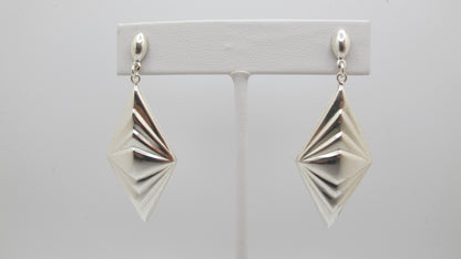 Pair of silver geometric earrings on a white background