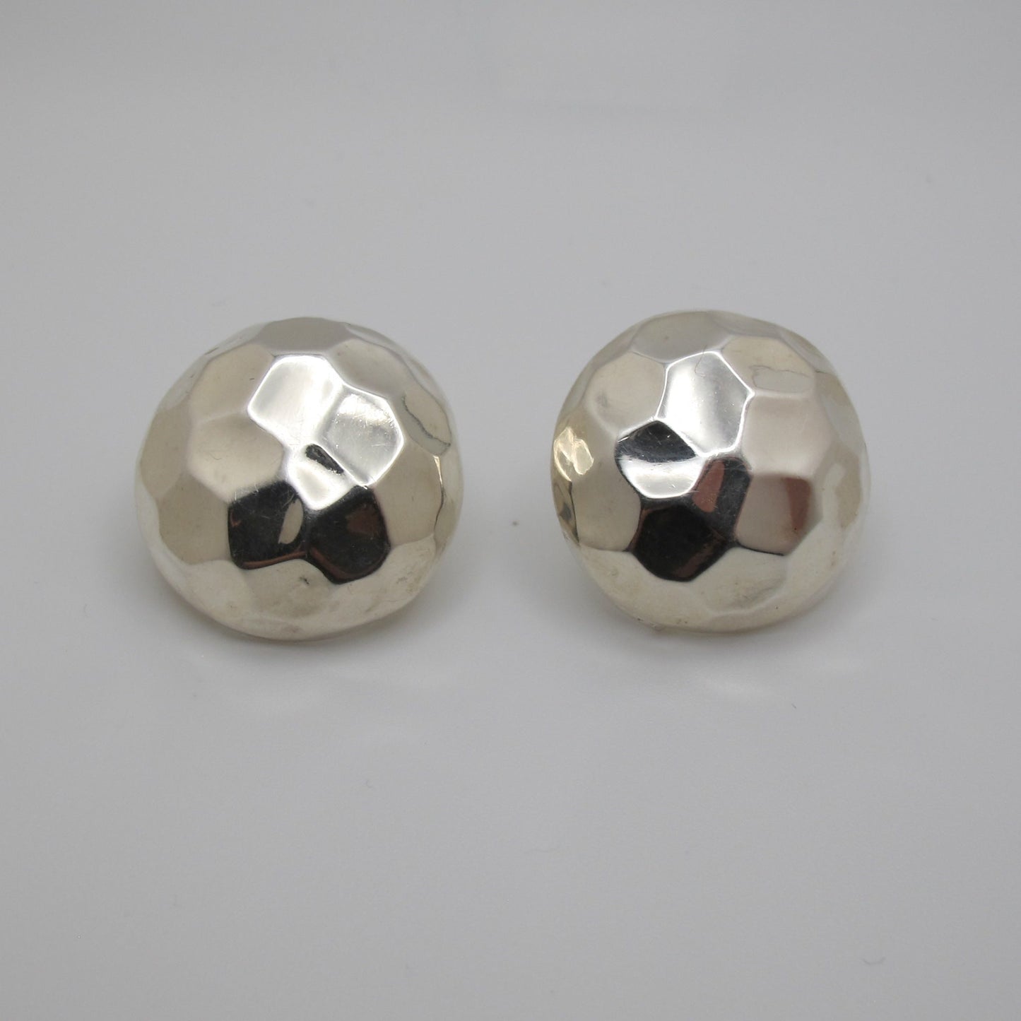 Pair of silver round earrings on a light gray background