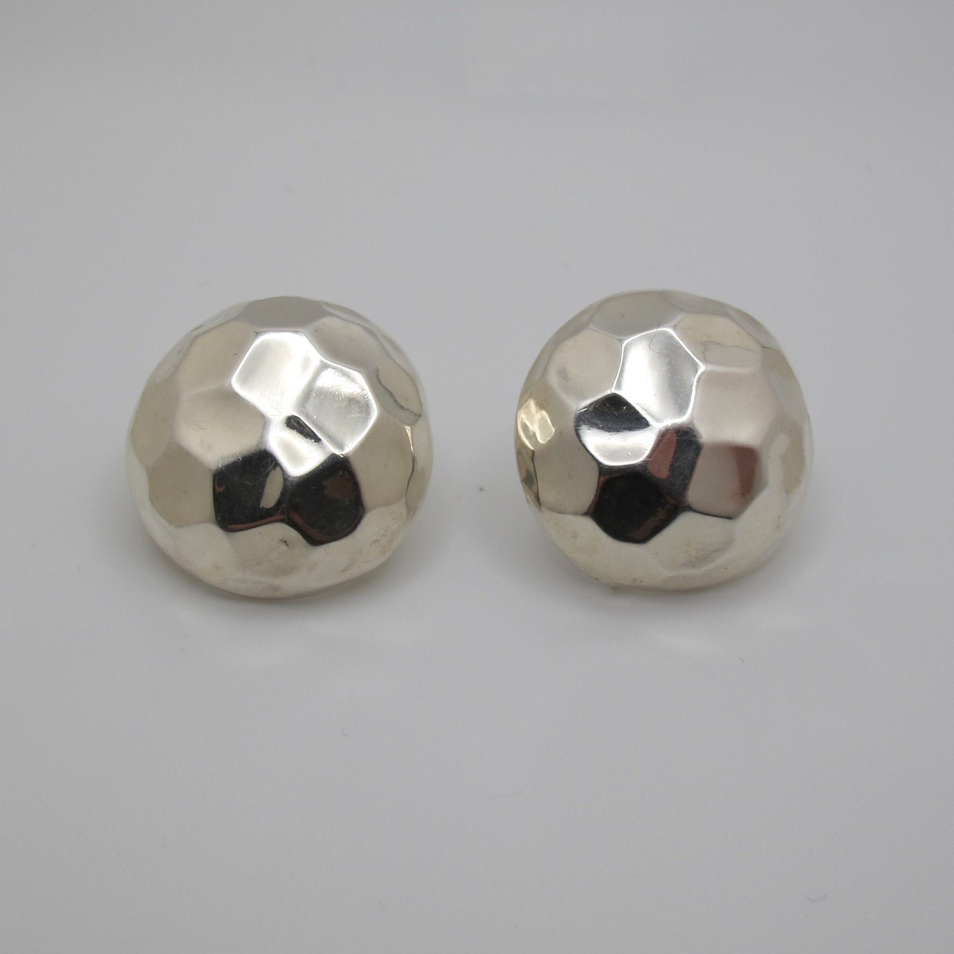 Pair of silver round earrings on a light gray background
