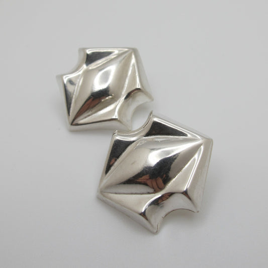 Pair of silver geometric earrings on a white background