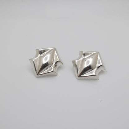Pair of silver geometric earrings on a white background