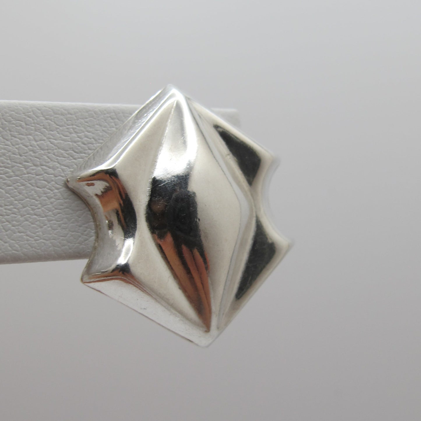 Silver star-shaped object on a white background
