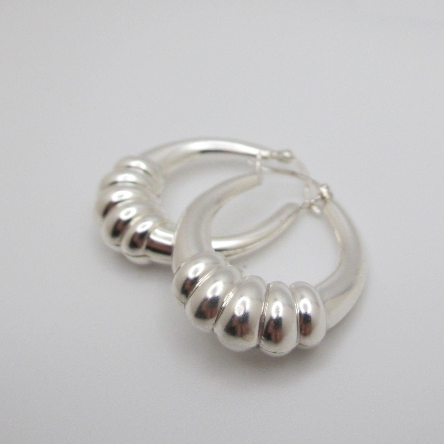 Silver hoop earrings on a light gray background