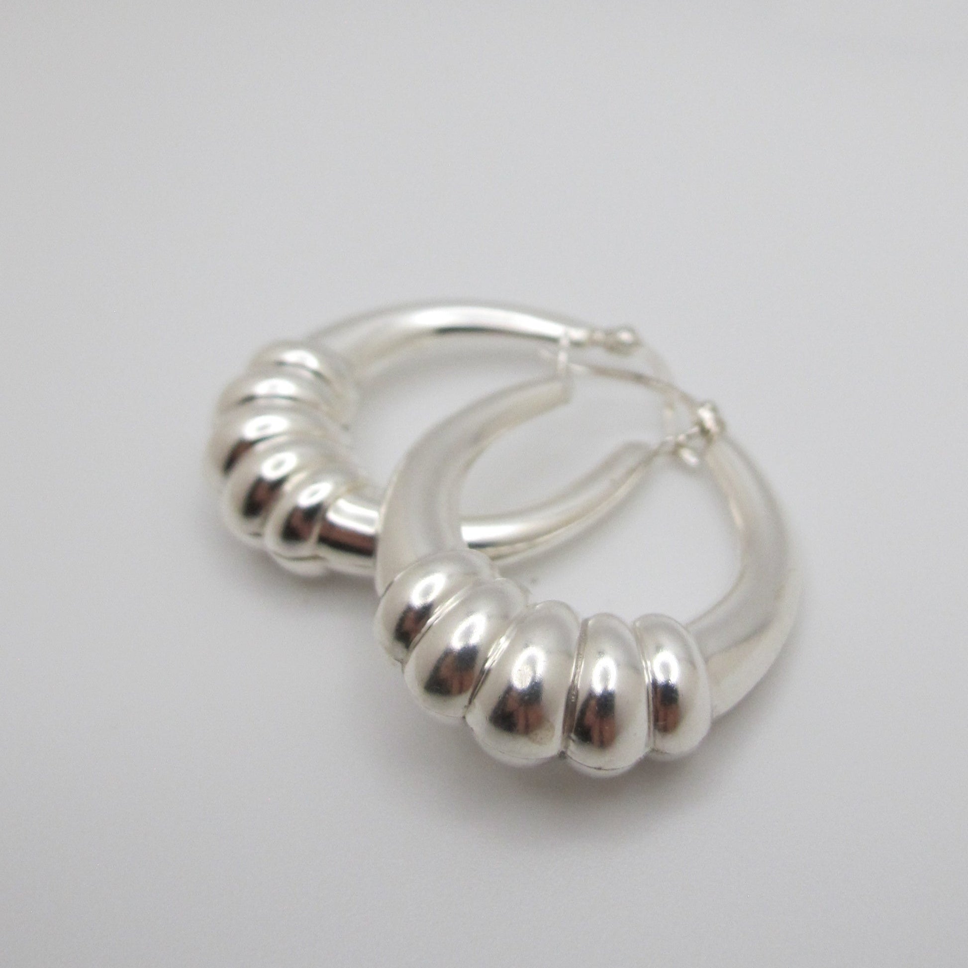 Silver hoop earrings on a light gray background
