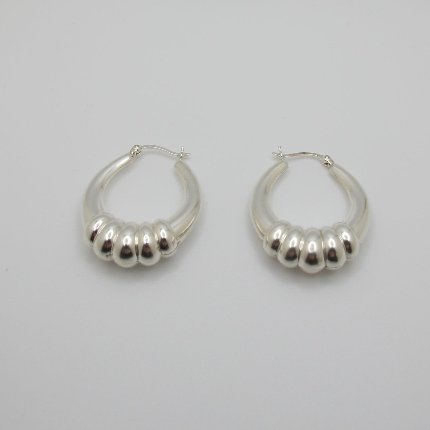 Pair of silver hoop earrings on a light gray background