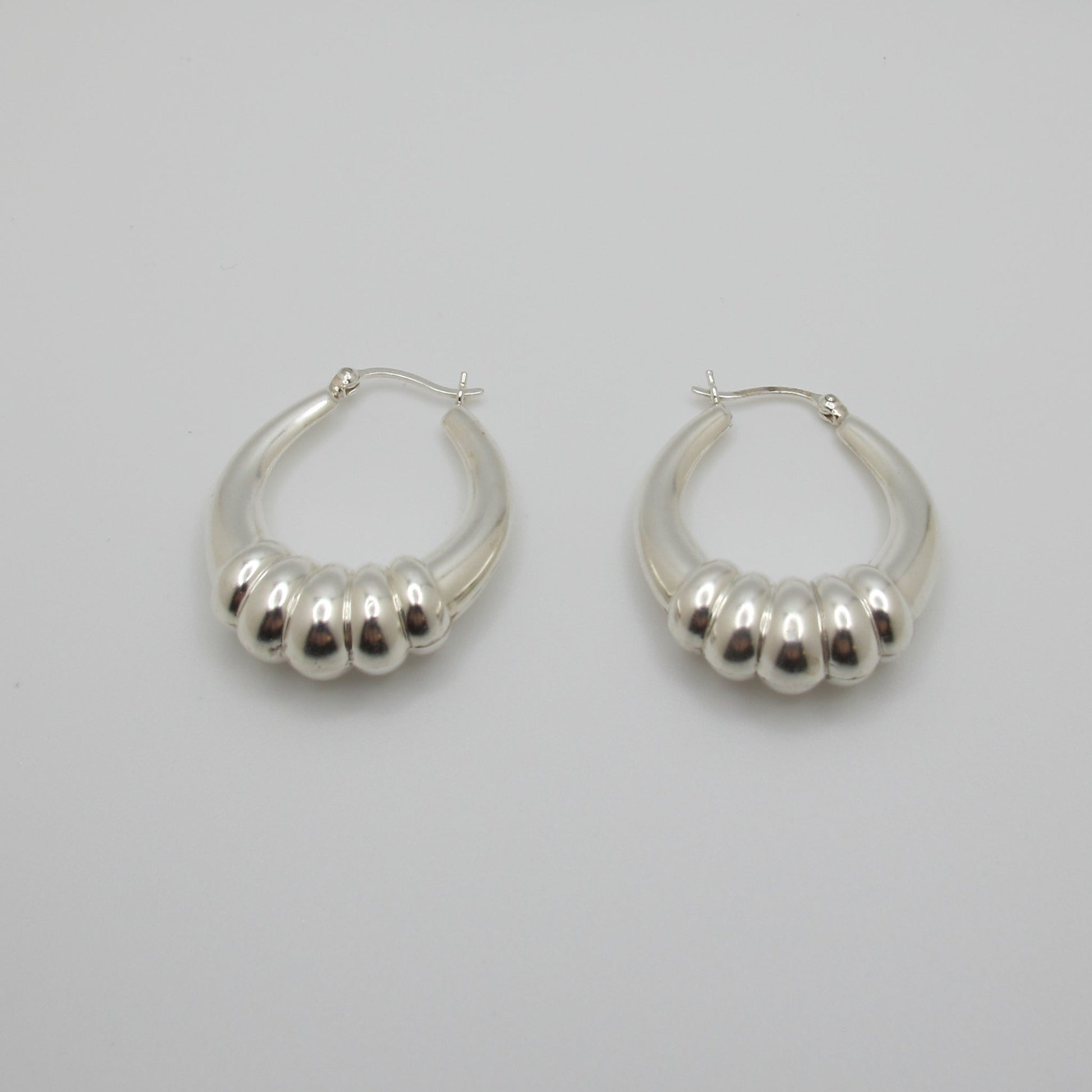 Pair of silver hoop earrings on a light gray background
